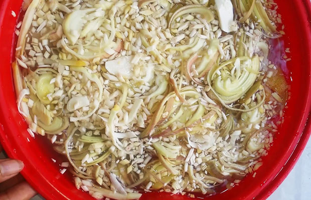 Bắp chuối bào đang được ngâm trong nước cốt chanh để giữ màu trắng và độ giòn cho món gỏi bò bóp thấu